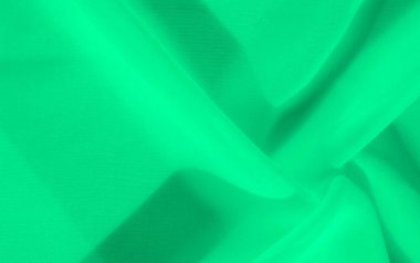 Hassas dokuları ve nazik hareketleri olan bulanık yeşil kumaş. Yumuşak kumaş dalgaları, yaratıcı arka planlarda ve tasarım çalışmalarında kullanmak için ideal, uyumlu ve sakin bir etki yaratır..