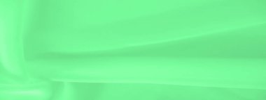 Bulanık yeşil kumaş yumuşak kıvrımlı, yumuşak kıvrımlı. Kumaşın soyut şablonu, kompozisyona sanatsal bir dokunuş ekleyerek sakin ve minimalist bir tasarım yaratıyor..