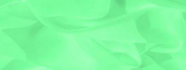 Bulanık yeşil kumaş yumuşak ışık ve gölgelerle yavaşça katlanarak pürüzsüz ve minimal bir görünüm yaratıyor. Akan doku dinamiktir ve tekstil hareketlerini çok güzel yakalar..