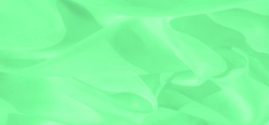 Yumuşak kıvrımları ve dinamik gölgeleri olan bulanık yeşil kumaş. Pürüzsüz doku soyut tasarım kavramları için mükemmel, zarif ve minimal bir estetik yaratıyor..