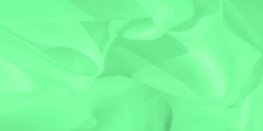 Bulanık yeşil kumaş görüntüde yavaşça katlanarak hareket ve akış hissi yaratır. Materyalin pürüzsüz dokusu ve nazik kıvrımları huzur verici ve rahatlatıcı bir görsel deneyim sunar..