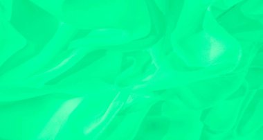 Pürüzsüz kıvrımları ve yumuşak gölgeleri olan bulanık yeşil kumaş. Akan doku zarif ve dinamik bir dokunuş ekler ve soyut bir tasarım yaratır..