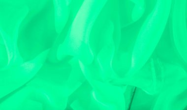 Bulanık yeşil kumaş yumuşak dalgalarla nazikçe örtülür, pürüzsüz dokusu ve akıcılığı sergilenir. Yumuşak, sakinleştirici tasarım, minimalist ve zarif bir görsel yaratıyor, modern estetik için mükemmel..