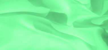 Bulanık yeşil kumaş yumuşak kıvrımları ve yumuşak kıvrımlı sıvı hareketlerini ortaya çıkarır. Pürüzsüz dokusu, sanatsal veya tasarım projeleri için mükemmel bir sakinlik ve basitlik hissi uyandırıyor..