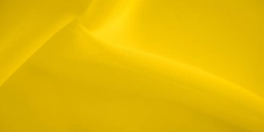 Dinamik bir görüntü oluşturan yumuşak, dalgalı sarı kumaşın bulanık görüntüsü. Parlak sarı ton, yaratıcı tasarım, moda veya soyut sanat kullanımları için ideal hale getirerek, canlı bir dokunuş ekler..