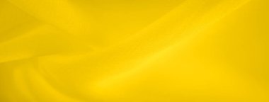 Bulanık sarı kumaş yumuşak kıvrımlar oluşturarak sıvı ve akışkan bir doku oluşturur. Canlı sarı renk tonu pürüzsüz kumaş yüzeyine parlaklık ve hareket ekler..