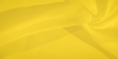 Pürüzsüz ve ince kıvrımlı sarı kumaşın bulanık görüntüsü. Kumaşın dokusu ışığı yakalıyor, arkaplan veya kumaşla ilgili temalar için temiz ve minimalist bir estetik sunuyor.