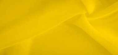 Bulanık sarı kumaş yumuşak kıvrımlar oluşturarak sıvı ve akışkan bir doku oluşturur. Canlı sarı renk tonu pürüzsüz kumaş yüzeyine parlaklık ve hareket ekler..