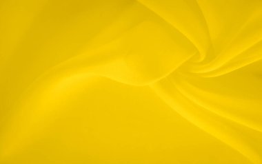 Sıvı kıvrımları ve yumuşak dokuları olan bulanık sarı kumaş, minimum ama dinamik bir bileşim oluşturuyor. Işık oyunu canlı rengi arttırır ve genel tasarıma derinlik ekler..