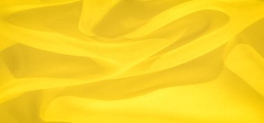 Yumuşak kıvrımlarda bulanık sarı kumaşlar, ılık ve sakin bir ortam yayıyor. Kumaşın akıcılığı ve parlayan dokusu onu barışçıl bir arkaplan yaratmak için ideal kılıyor..