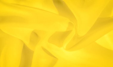 İnce kıvrımları ve kıvrımları olan parlak sarı kumaşın bulanık görüntüsü. Yumuşak dokusu ve canlı tonu çeşitli yaratıcı kullanım için asgari soyut bir arkaplan oluşturur.