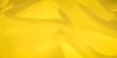 Yumuşak kıvrımlı bulanık sarı kumaş dokusu yumuşak ve pürüzsüz bir soyut desen oluşturuyor. Parlak renk ışık ve gölge oyunlarını vurgular ve tekstil yüzeyine derinlik katar..