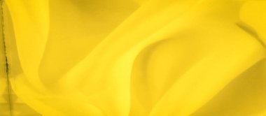 İnce kıvrımları ve kıvrımları olan parlak sarı kumaşın bulanık görüntüsü. Yumuşak dokusu ve canlı tonu çeşitli yaratıcı kullanım için asgari soyut bir arkaplan oluşturur.