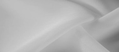 İnce kıvrımları ve pürüzsüz bir dokusu olan bulanık beyaz bir kumaş. Görüntü, materyalin hassas akışını yakalar, yumuşaklığını ve saflığını vurgular, arka plan ve dokular için mükemmeldir..