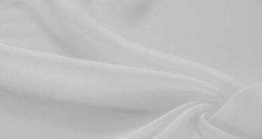Yumuşak beyaz kumaşın bulanık görüntüsü yumuşak kıvrımlar ve kıvrımlar oluşturuyor, temiz ve pürüzsüz bir doku yaratıyor. Hassas malzeme, tasarım geçmişi için ideal, sakin ve minimalist bir his sunar..