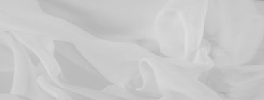 Bulanık beyaz kumaş, yumuşak, akışkan desenler halinde katlanmış. Doku ve ince gölgeler temiz, minimalist bir estetik yaratıyor, modern tasarım arka planları veya tekstil odaklı projeler için ideal..
