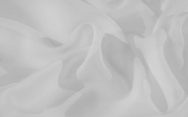 Bulanık beyaz kumaş, yumuşak, akışkan desenler halinde katlanmış. Doku ve ince gölgeler temiz, minimalist bir estetik yaratıyor, modern tasarım arka planları veya tekstil odaklı projeler için ideal..