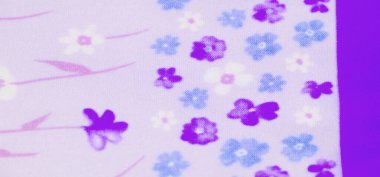 Bulanık çiçekli kumaş. Mavi, mor ve beyaz çiçeklerin büyüleyici bir karışımı. Yumuşak lavanta arkaplan ve narin çiçek motifleri tuhaf, rüya gibi bir doku yaratır..