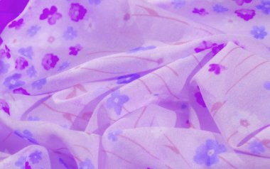 Menekşe, mavi ve pembe renklerde detaylı bir çiçek tasarımı içeren canlı mor kumaşın bulanık yakın plan görüntüsü. Yumuşak, akışkan madde rüya gibi ve sanatsal estetiğini geliştirir..