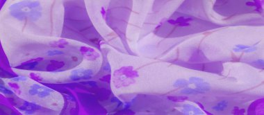 Mavi, mor ve beyaz çiçeklerden oluşan narin çiçek desenli bulanık mor kumaş. Yumuşak kumaş kıvrımları dokusunu geliştirir, dingin ve kadınsı bir atmosfer yaratır..