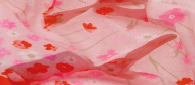 Pembe, turuncu ve kırmızı yumuşak tonlarda küçük çiçek desenleriyle süslenmiş akışkan pembe kumaşın bulanık görüntüsü. Kumaşın şeffaf kalitesi koyu kırmızı çizgilerle tamamlanır.