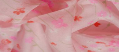 Kırmızı ve pembe çiçeklerden oluşan tuhaf çiçek desenli pembe bir kumaş bulanıklığı. Kumaşın yumuşak kıvrımları akışkan bir hareket yaratırken, ışık ve gölge saf hava dokusuna derinlik katıyor.