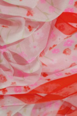 Pembe kumaştan bir bulanıklık, pembe ve kırmızı tonlarda yumuşak çiçek desenleriyle süslenmiş, hassas dokular ve akan kıvrımlar sergiliyor. Soyut tasarım hafiflik ve yumuşaklığı vurgular..