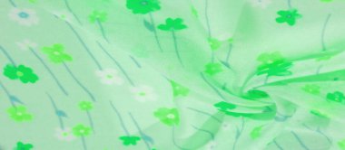 Yumuşak yeşil kumaştan bir bulanıklık, yeşilin çeşitli tonlarında canlı çiçek unsurlarıyla süslenmiş. Kumaşın hafif dokusu ve narin kıvrımları ona havadar, akışkan bir görünüm veriyor, tasarım için mükemmel.