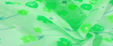 Yumuşak yeşil kumaştan bir bulanıklık, yeşilin çeşitli tonlarında canlı çiçek unsurlarıyla süslenmiş. Kumaşın hafif dokusu ve narin kıvrımları ona havadar, akışkan bir görünüm veriyor, tasarım için mükemmel.