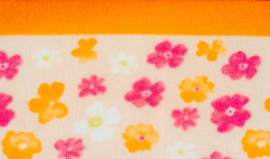 Yumuşak turuncu, pembe ve beyaz çiçeklerle bej arkaplana saçılmış çiçek kumaşı bulanıklığı. İnce doku ve ılık renk paleti kumaş için hassas ve samimi bir his yaratır..