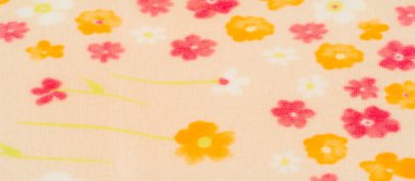 Yumuşak pembe, turuncu ve beyaz çiçekli narin çiçek kumaşı soluk bej arkaplana saçılmış. Renklerin eğimi sıcak ve davetkar bir doku yaratır..