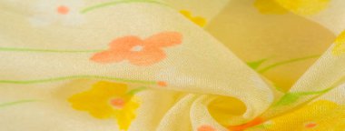 Sarılı yumuşak çiçekli kumaş bulanıklığı ve canlı pastel çiçekleri. Akan madde ve ışık, şeffaf doku koyu sarı bir süsleme ile vurgulanır, taze, bahar benzeri bir estetik yaratır..