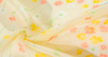Yumuşak ve akışkan sarı çiçekli kumaş narin pembe ve turuncu çiçekler hafif, havadar bir doku oluşturur. Yumuşak kıvrımlar ve şeffaf kumaş durgun ve yaz hissi uyandırıyor..