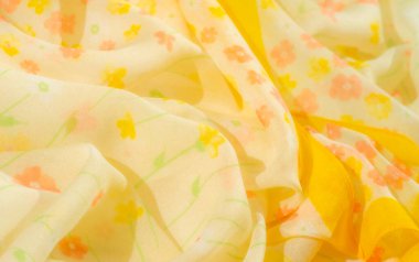 Açık sarı kumaş bulanıklığı ve yumuşak çiçek desenli pastel gölgeler. Akan kumaş, turuncu ve sarı narin çiçekler içerir. Huzurlu, doğadan esinlenilmiş bir estetik oluşturur.