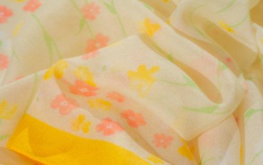 Çiçek desenleri yayılmış yumuşak sarı kumaş bulanıklığı, turuncu, beyaz ve sarı tonlarını da içeriyor. Hassas kıvrımlar kumaşa doğal bir akış getiriyor ve tazeliği çağrıştırıyor.