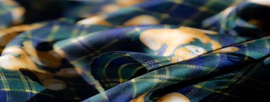 Sarı çiçekli bir kenar ve oyuncak ayı figürleriyle sarılmış yeşil ekose kumaş bulanıklığı. Yumuşak kıvrımlar sanatsal desenleri ve karmaşık çiçekli tasarımları gözler önüne seriyor, rahat iç mekanlar için mükemmel..