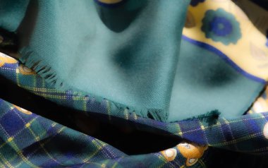 Sarı ve yeşil çiçekli kumaş, neşeli oyuncak ayılar, ekose bir arka plan. Renklerin ve kalıpların birleşimi çekici ve dinamik bir kumaş tasarımı yaratır..