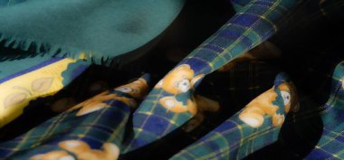 Ekoseli arka planda canlı yeşil ve sarı bir kumaş, oyuncak ayı ve çiçek aksanlı. Dinamik, oyuncu tasarım çeşitli kullanım alanları için mükemmel, neşeli, sanatsal bir his yaratır..