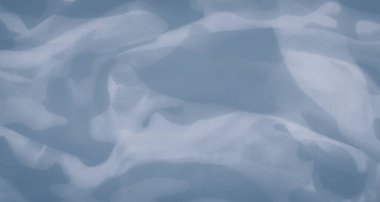 Göksel mavi kumaşın bulanıklığı yumuşak bir şekilde aydınlatılarak akışkan, havadar bir doku oluşturur. Işık ve gölgenin etkileşimi soyut ve hassas maddeye derinlik ve hareket katar..