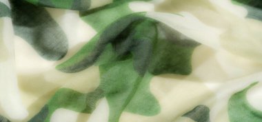 Aydınlık ve havadar bir kamuflaj deseni olan yeşil ve bej kumaştan zahmetsizce akar. Yumuşak dokular ve organik şekiller bir huzur ve doğal güzellik hissi yayar..