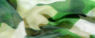 Hafif, şeffaf bir kumaşın bulanıklığı canlı yeşil ve bej bir kamuflaj deseni sergiliyor. Kumaş nazikçe akar, yumuşak dinamik bir etki yaratır. Tekstil ve yaratıcı arka planlar için mükemmel.