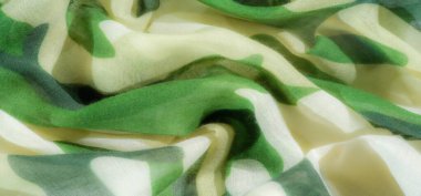 Açık renkli ve havadar kamuflaj desenli kumaş, ince kıvrımlı, çeşitli yeşil ve bej tonlarını karıştırıyor. Yumuşak, akışkan doku doğal ve soyut cazibeyi arttırır..