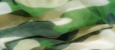 Yeşil ve bej renklerin birlikte aktığı kamuflaj kumaşı bulanıklığı. Soyut şekiller ve yumuşak doku, çok yönlü kullanım için mükemmel, doğadan esinlenilmiş, uyumlu bir kumaş deseni yaratır..