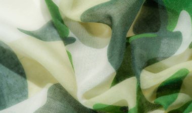 Pürüzsüz kıvrımlı, yumuşak, akan yeşil ve bej rengi bir kamuflaj kumaşı doğal ve organik bir his veriyor. Kumaş, birbirine karışan yeşilin çeşitli tonlarına sahiptir.,