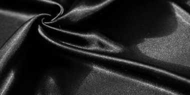 Yumuşak, akışkan siyah kumaştan ince kıvrımlı bir bulanıklık. Parlak yüzey, ışık ve gölge arasındaki zıtlığı arttırır. Lüks ve pürüzsüz bir doku sergiler..