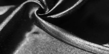 Yumuşak, akışkan siyah kumaştan ince kıvrımlı bir bulanıklık. Parlak yüzey, ışık ve gölge arasındaki zıtlığı arttırır. Lüks ve pürüzsüz bir doku sergiler..