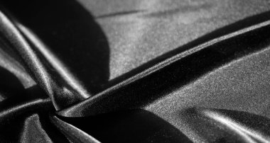 Zarif kıvrımlarla kıvrılmış yumuşak siyah kumaş bulanıklığı. Pürüzsüz bitiş ve pürüzsüz doku, ışık ve gölgenin çekici bir kontrastını yaratarak kumaşa lüks bir görünüm kazandırıyor..