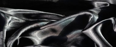 Yumuşak, dalgalı siyah kumaşlı, ince ışıklı röfleli. Pürüzsüz madde, göze çarpan parlak bir yüzeyi olan zengin bir görüntü yaratır..