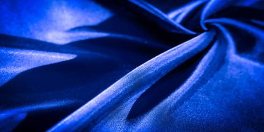 Yumuşak kıvrımlı ve pırıl pırıl ışık saçan ipek mavisi kumaşın Görüntü Vibrant yakın çekim. Soyut doku, zarafet ve hareketi çağrıştıran pürüzsüz dalgaları ve akış şekillerini vurgular.
