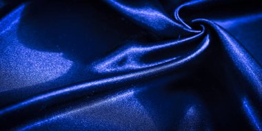 Pürüzsüz, zarif kıvrımlı mavi kumaştan çarpıcı bir makro çekim. Kumaşın dokusu ve parıltısı, moda, sanat veya iç tasarım tasarımı için ideal, sofistike bir his sağlıyor..